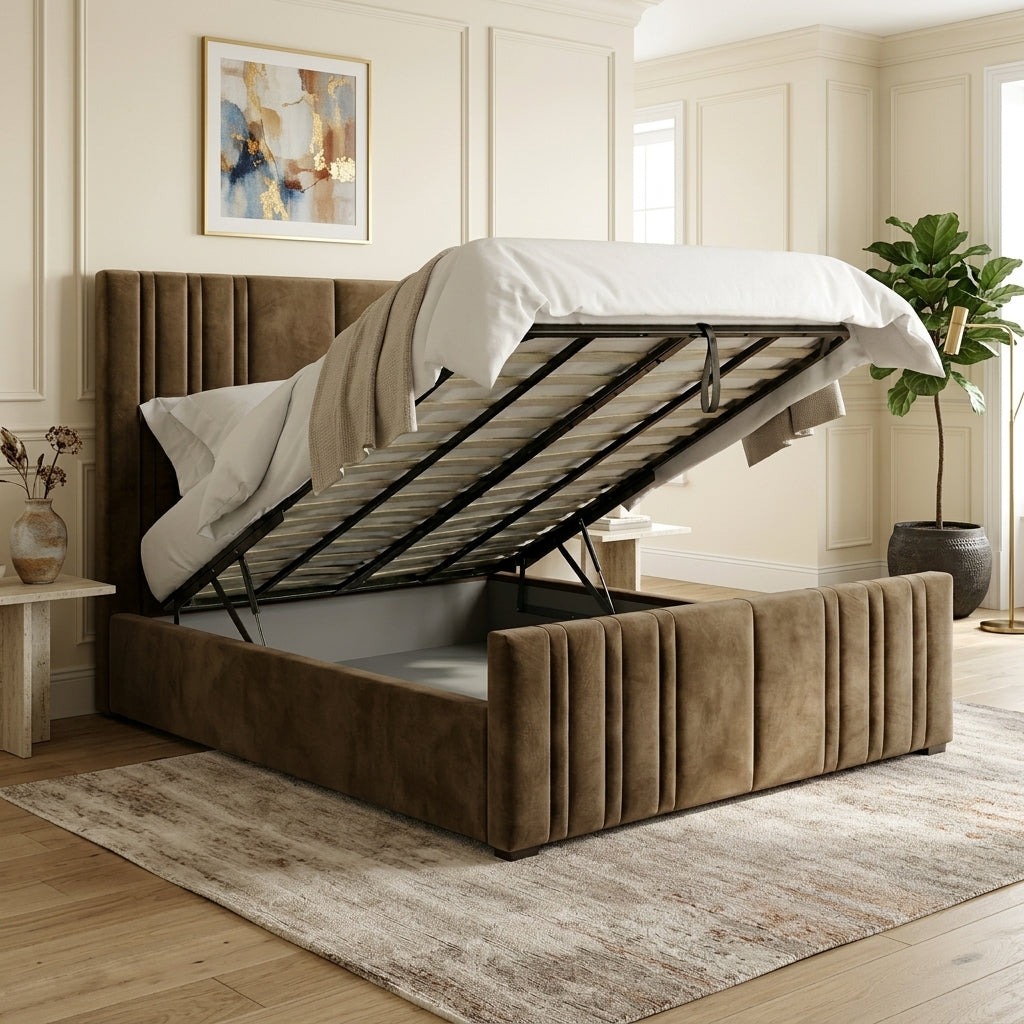 A brown upholstered storage bed with a raised gas-lifted frame, shown in a styled bedroom with white bedding, a patterned rug, and wall decor.
