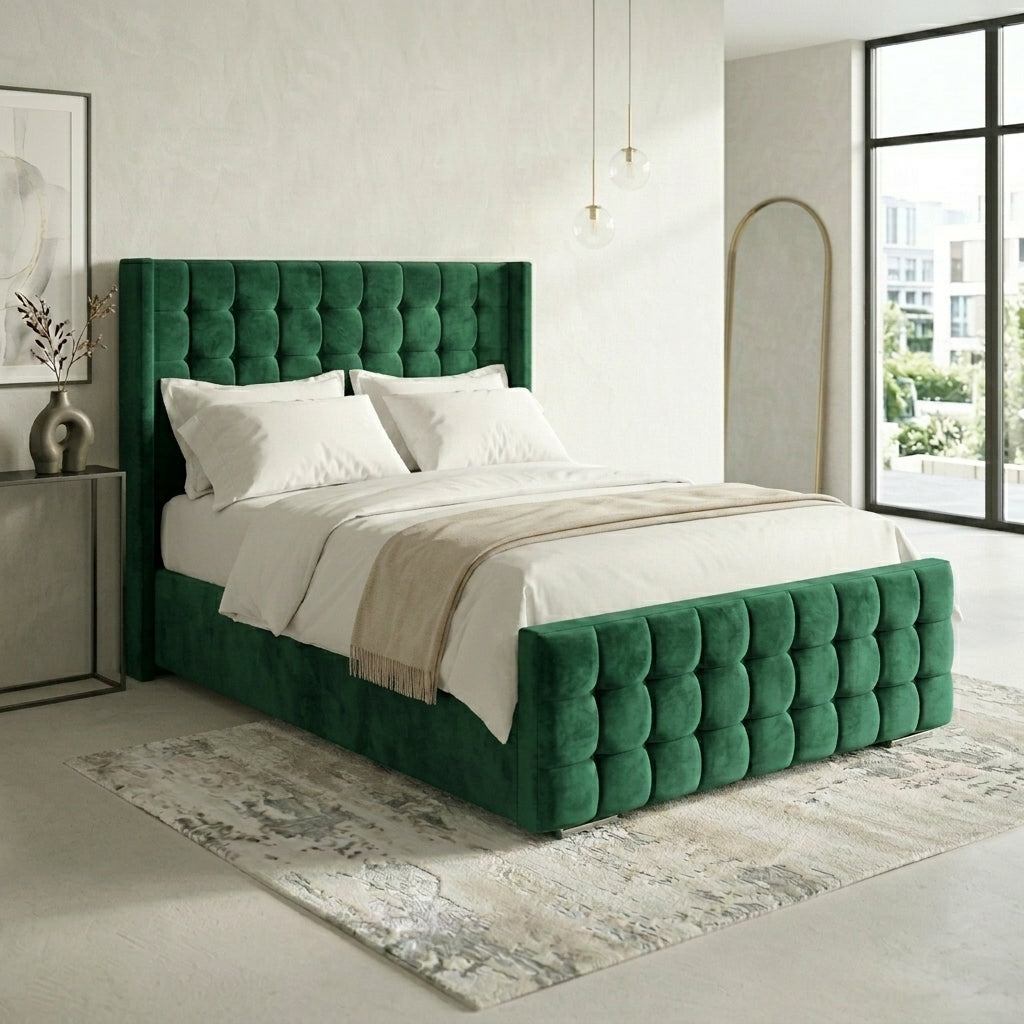 A modern tufted bed frame in deep emerald green velvet, styled with white bedding and a beige throw blanket in a bright, contemporary bedroom.