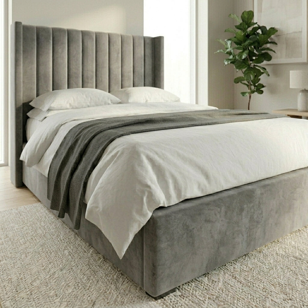 A modern upholstered Wing bed with a tall channel-tufted headboard and matching footboard, dressed in white bedding shown in a bright bedroom setting.
